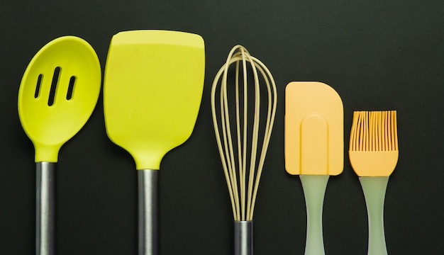 Silicone kitchen tools on a black background. Top view.