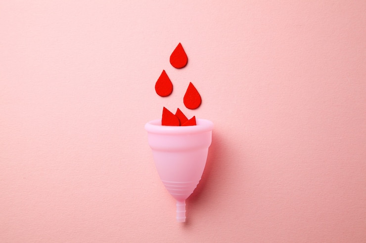 Photo silicone menstrual cup with paper drops of blood