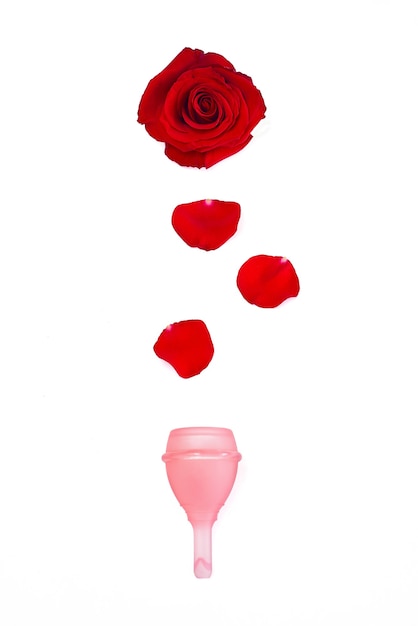 Photo silicone pink menstrual cup with rose on white background, menstruation concept