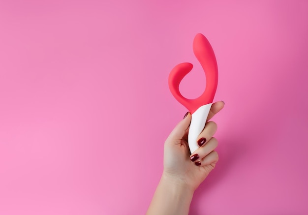 분홍색 배경에 실리콘 섹스 토이. 재미를 위한 에로틱 장난감. 섹스 가제트 및 자위 기구.
