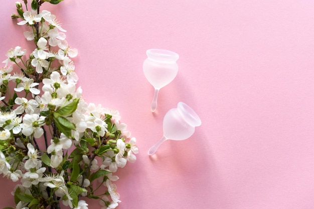 Siliconen menstruatiecup Gezondheid voor vrouwen en alternatieve hygiëne Cup met lentebloemen op een roze achtergrond Geen afval alternatieven
