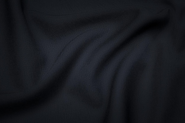 Silk or cotton or wool fabric tissue. Dark gray or black color. Texture, background, pattern.