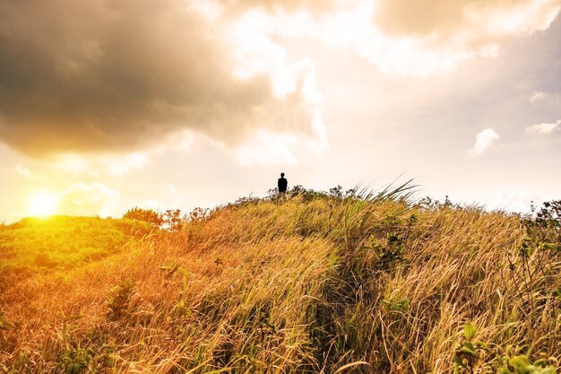 Sillouette человек стоит на пике горного луга золотой блестящий