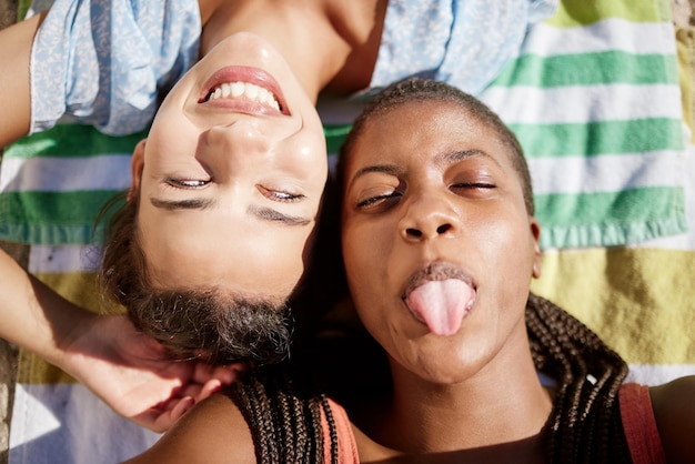 Silly friends beach vacation and women having fun while sticking out tongue and taking a selfie while on a beach vacation in summer Closeup face of diversity friendship and tropical happiness