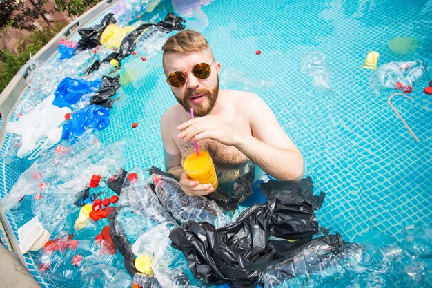 silly man swim and have fun in a polluted pool. Bottles and plastic bags float near them.