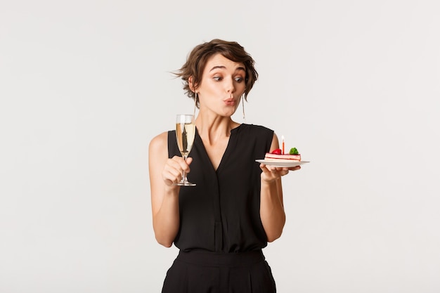 Silly pretty girl celebrating her birthday, holding glass of champagne