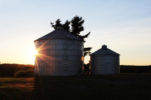 silos against sky during sunset