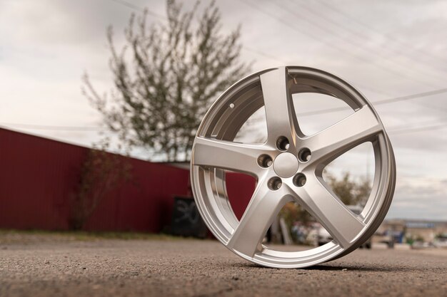 Silver aluminum alloy wheel outdoor under the open sky.