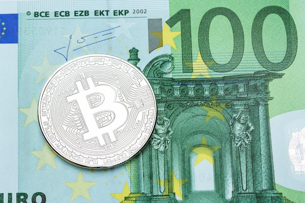 Фото Серебряный биткойн на банкноте 100 евро на макросе