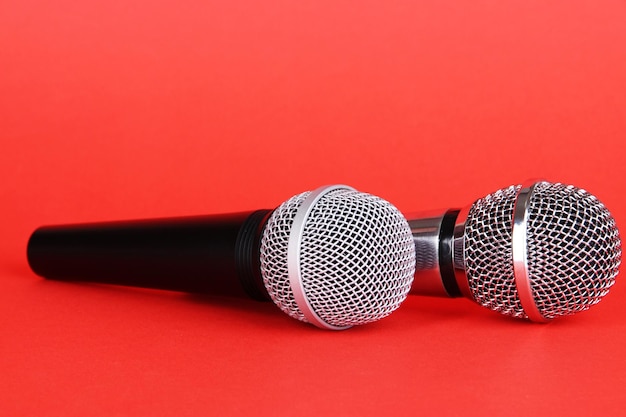 Silver and black microphones on red background