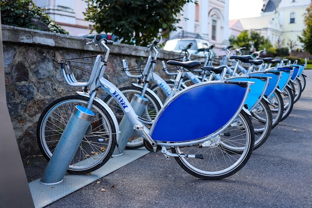 Серебристо-синий велосипед на стоянке, прокат велосипедов