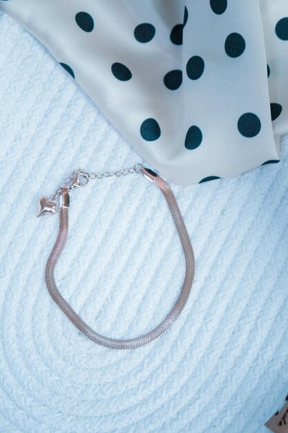 a silver bracelet with black dots and a white polka dot.