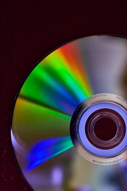 写真 表面全体に虹色の光がバーストした、暗い背景に銀色の cd