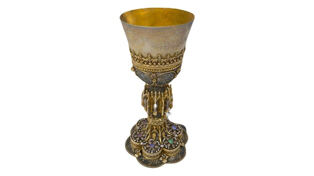 A silver chalice with a stone design on the bottom.