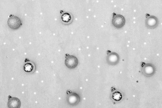 Photo silver christmas balls laid out on the table with sequins in the form of stars.