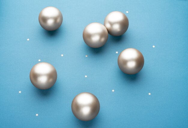 Silver Christmas balls on a light blue background with stars