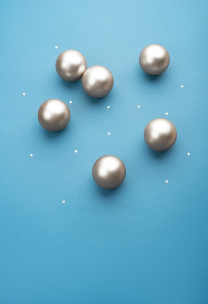 Silver Christmas balls on a light blue background with stars