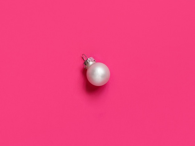 Silver Christmas bauble on a pink background