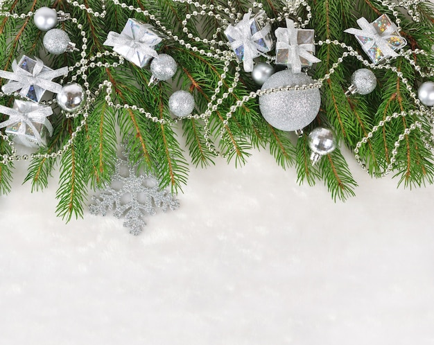 흰색 바탕에 가문비나무 가지에 은색 크리스마스 장식