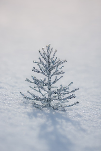 屋外の本物の雪の上の銀のクリスマスツリーの装飾。冬の休日の概念