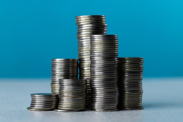 Silver coins in stacks on a blue background