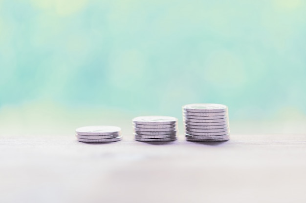 Silver coins on wooden table, saving money concept