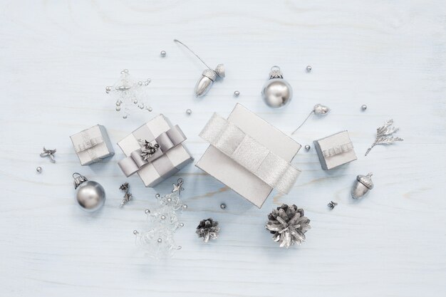 Silver colored gift boxes and Christmas decorations on light blue table