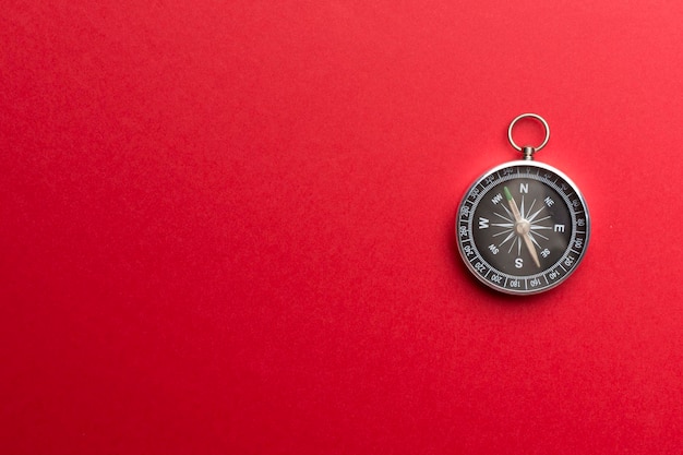 Silver compass on color background top view