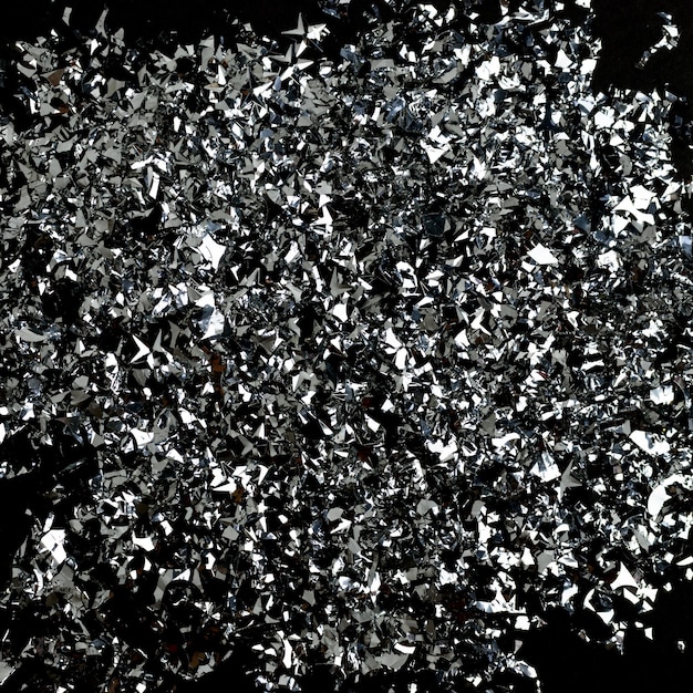 Silver confetti texture on a black background