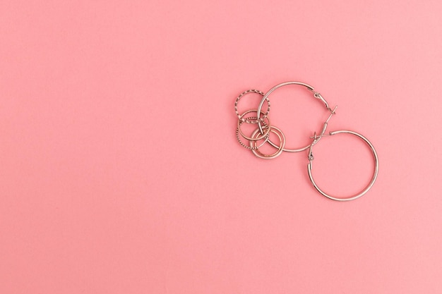 Silver costume jewelry on a delicate pink background advertising shoot