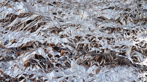 Silver crumpled foil texture background