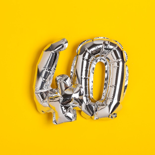 Silver foil number 40 celebration balloon on a bright yellow background
