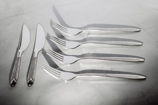 Silver forks on white marble background Mockup