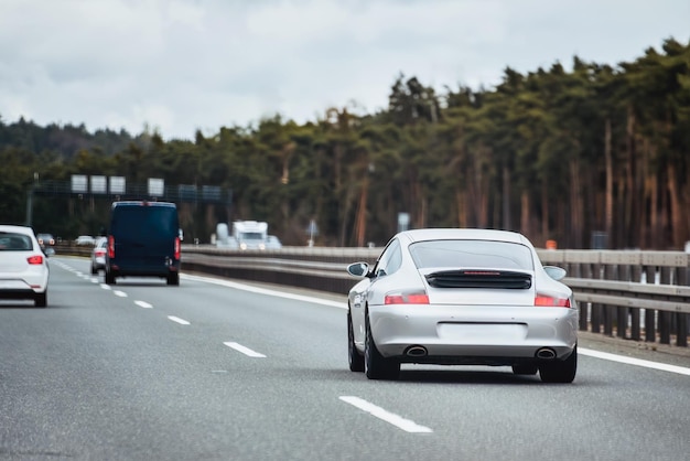 高速道路を走る銀色のドイツのロードスタークーペ 銀色のスポーツクーペ 高価なスポーツカーが高速道路を走っている