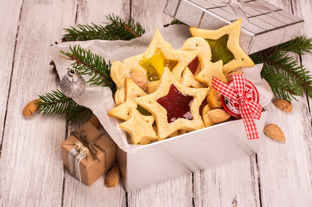 집에서 만든 별 모양의 쿠키와 은색 선물 상자입니다. 크리스마스 또는 새해 카드.