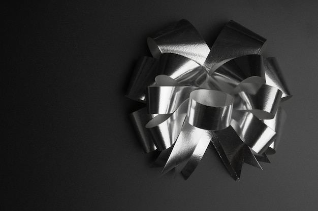 Silver gift ribbon with gift paper on black background.