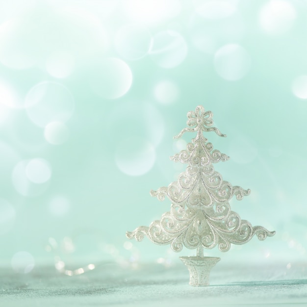 Silver glitter Christmas tree on blue background with lights bokeh, copy space. 