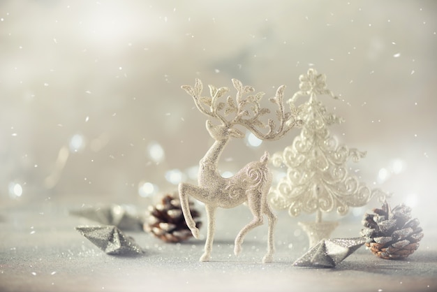 Silver glitter Christmas tree, deer, cones on grey background with lights bokeh, copy space. 