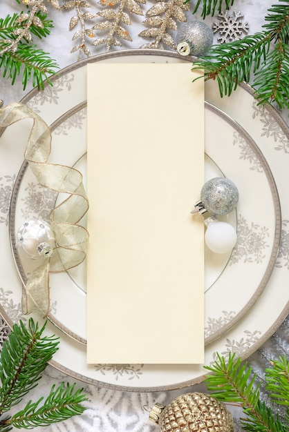 Photo silver and golden festive table setting with ornaments and fir tree branches with blank card