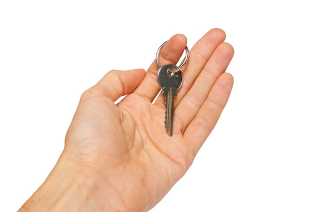 Silver key in a hand isolated on white.