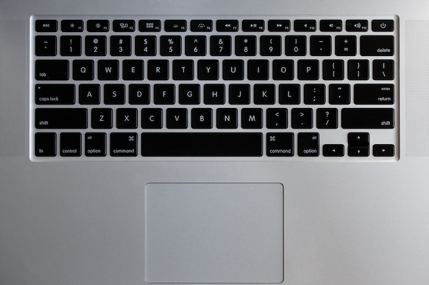 黒いボタンが付いたシルバーのノートパソコンのキーボード