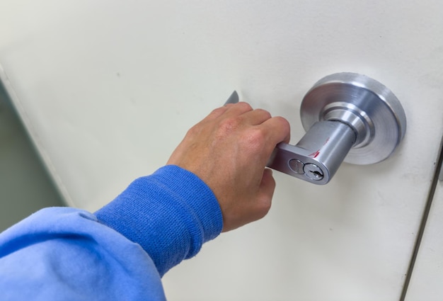 Silver metal door handle against a dark wood door the handle's curved design exudes modern elegance