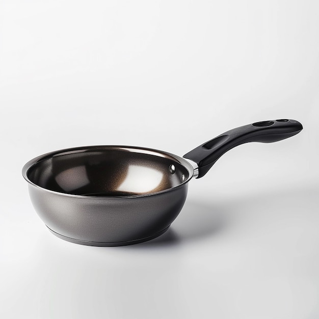 a silver pan with a black handle is on a white surface