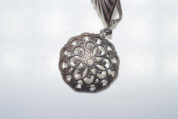 Photo a silver pendant with a flower design on it.