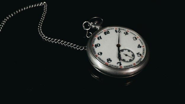 A silver pocket watch with the number 12 on it