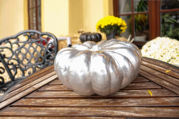 ハロウィン祭りの木製のヴィンテージテーブルに銀の塗料で塗装された銀の南瓜