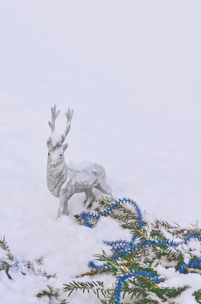 シルバートナカイのおもちゃ白い雪の背景にシルバーグレーの光沢のあるクリスマストナカイ