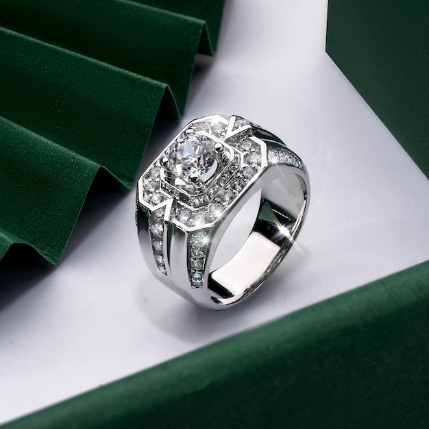 A silver ring with a diamond on it sits on a green box.