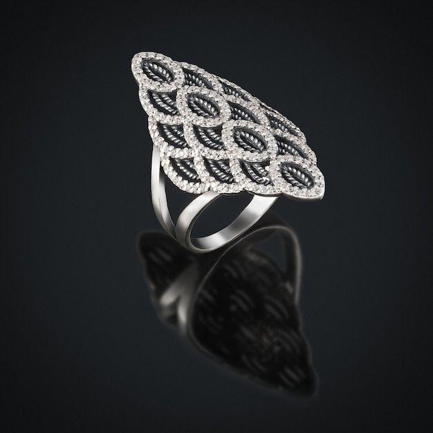 Серебряное кольцо с отблеском на черном фоне с цветным пятном в центре оправы