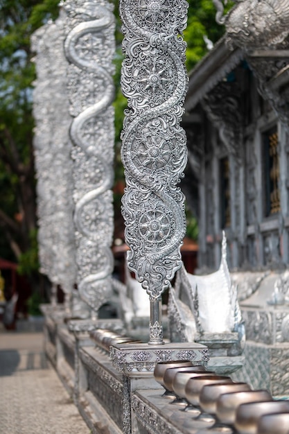 A silver sculpture of a snake on a wall